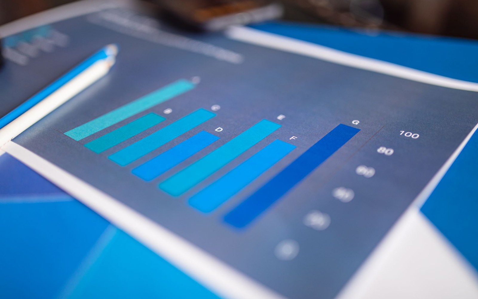 Printed bar chart with a blue gradient scale lies on a folded blue brochure